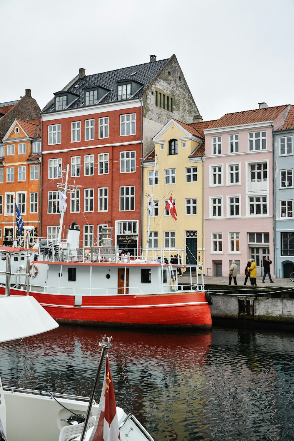 red boat on side of road near buildings