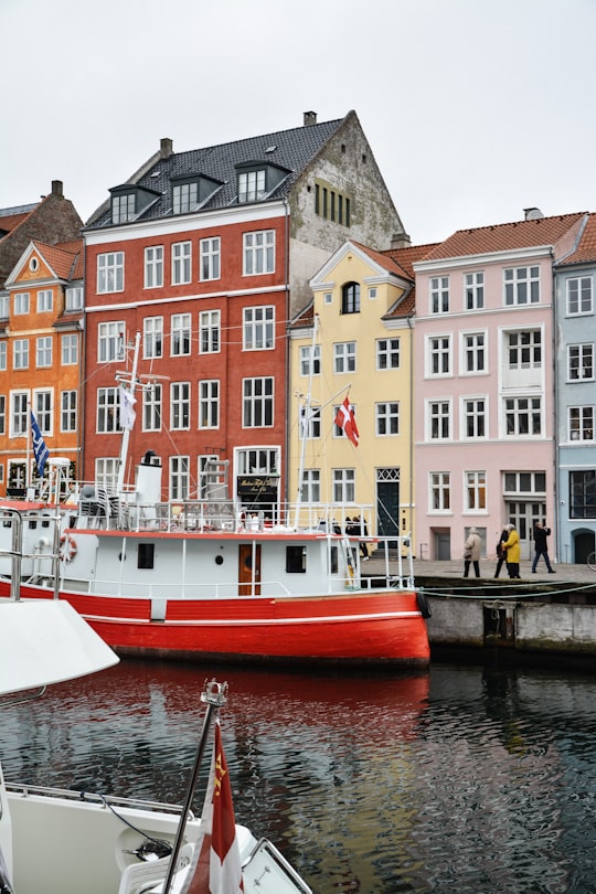 red boat on side of road near buildings in Mindeankeret Denmark