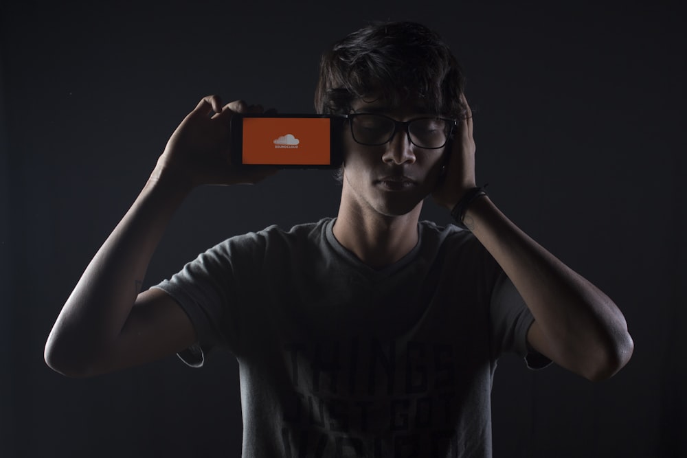 Mann hört Soundcloud-Musik auf dem Smartphone