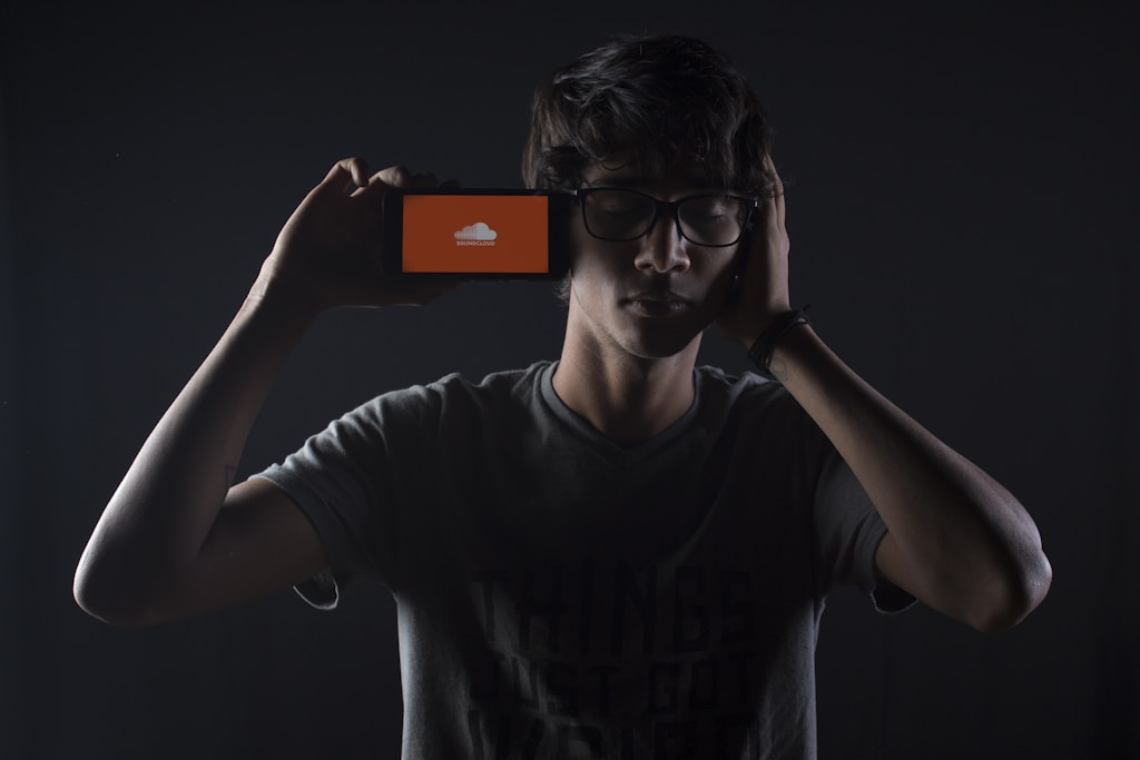 man listening to Soundcloud music on smartphone