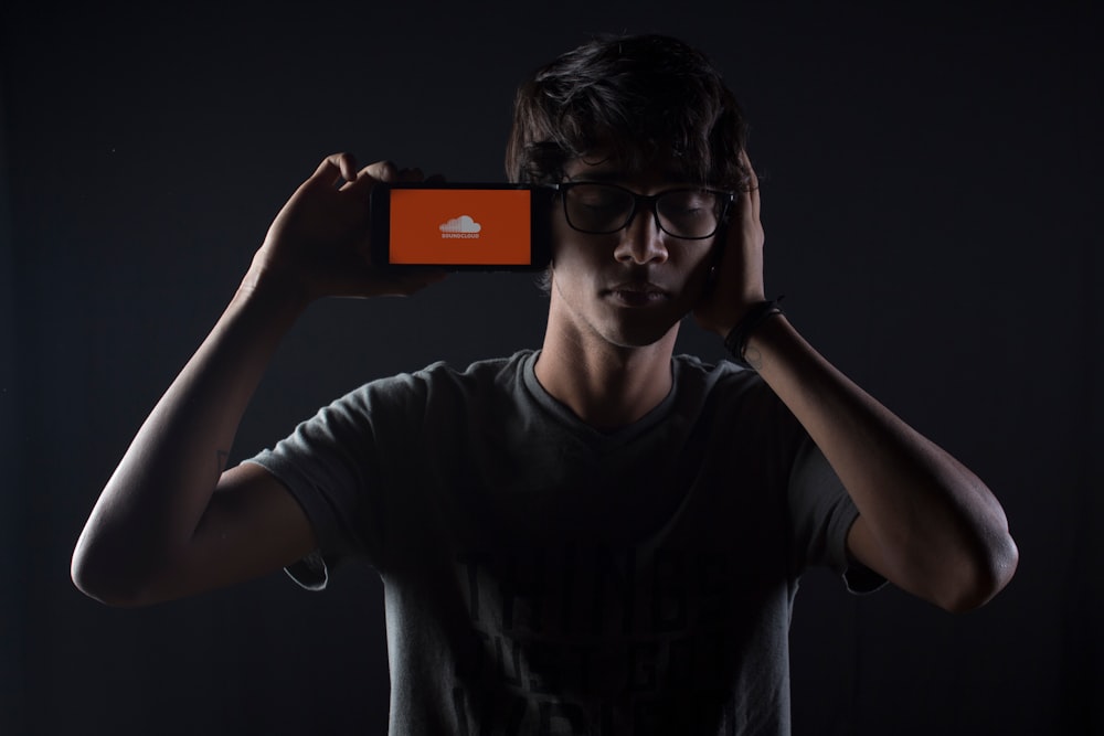 man listening to Soundcloud music on smartphone