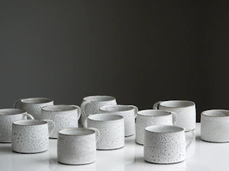 white ceramic mug lot on white surface