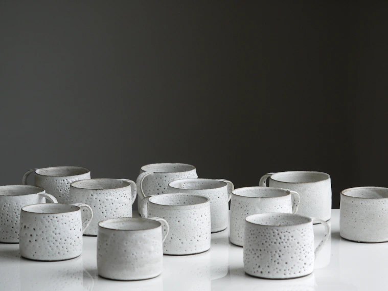 white ceramic mug lot on white surface
