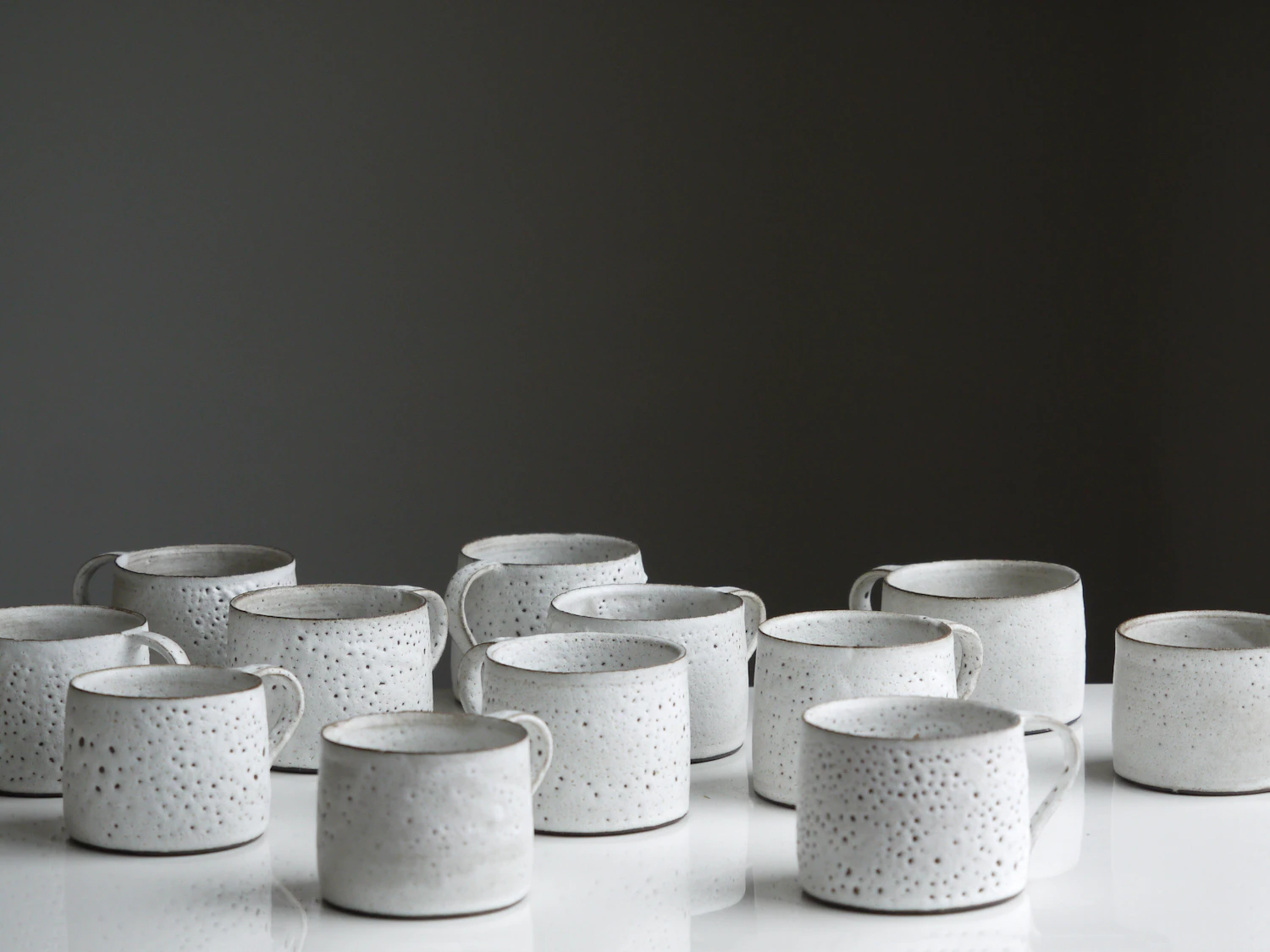 Grana espresso cups, a row of small speckled stoneware cups on a white surface