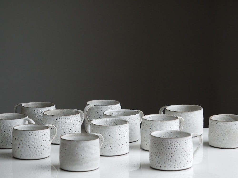 white ceramic mug lot on white surface