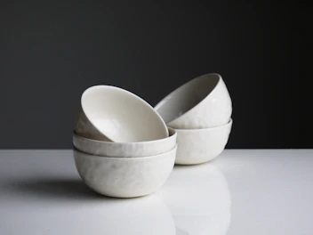 Vibrant ceramic bowls stacked neatly with a cozy kitchen background.
