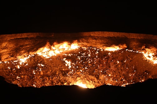 A fiery hellscape with dark shadows and glowing embers.