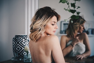 femme aux cheveux blonds se couvrant le corps avec une serviette blanche