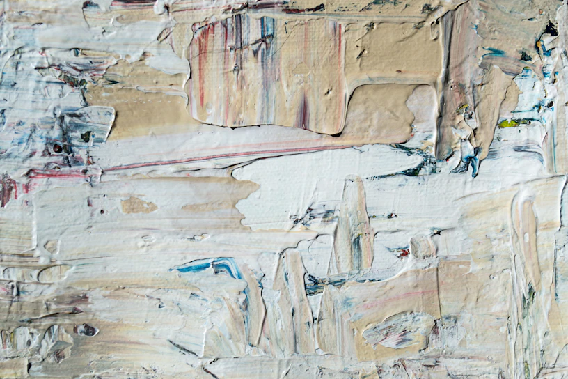 Close-up of a textured abstract painting in soft beige and gray tones.