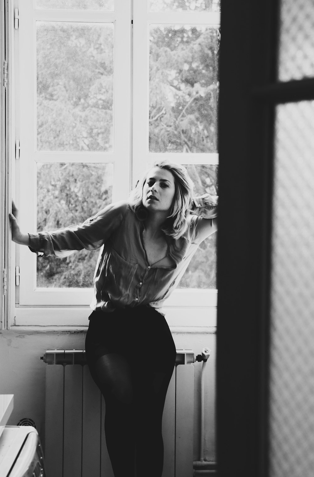 woman sitting on radiator heater