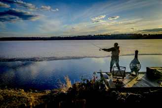 An angler peacefully fishing off the dock with morning light glowing over Lake Erie.