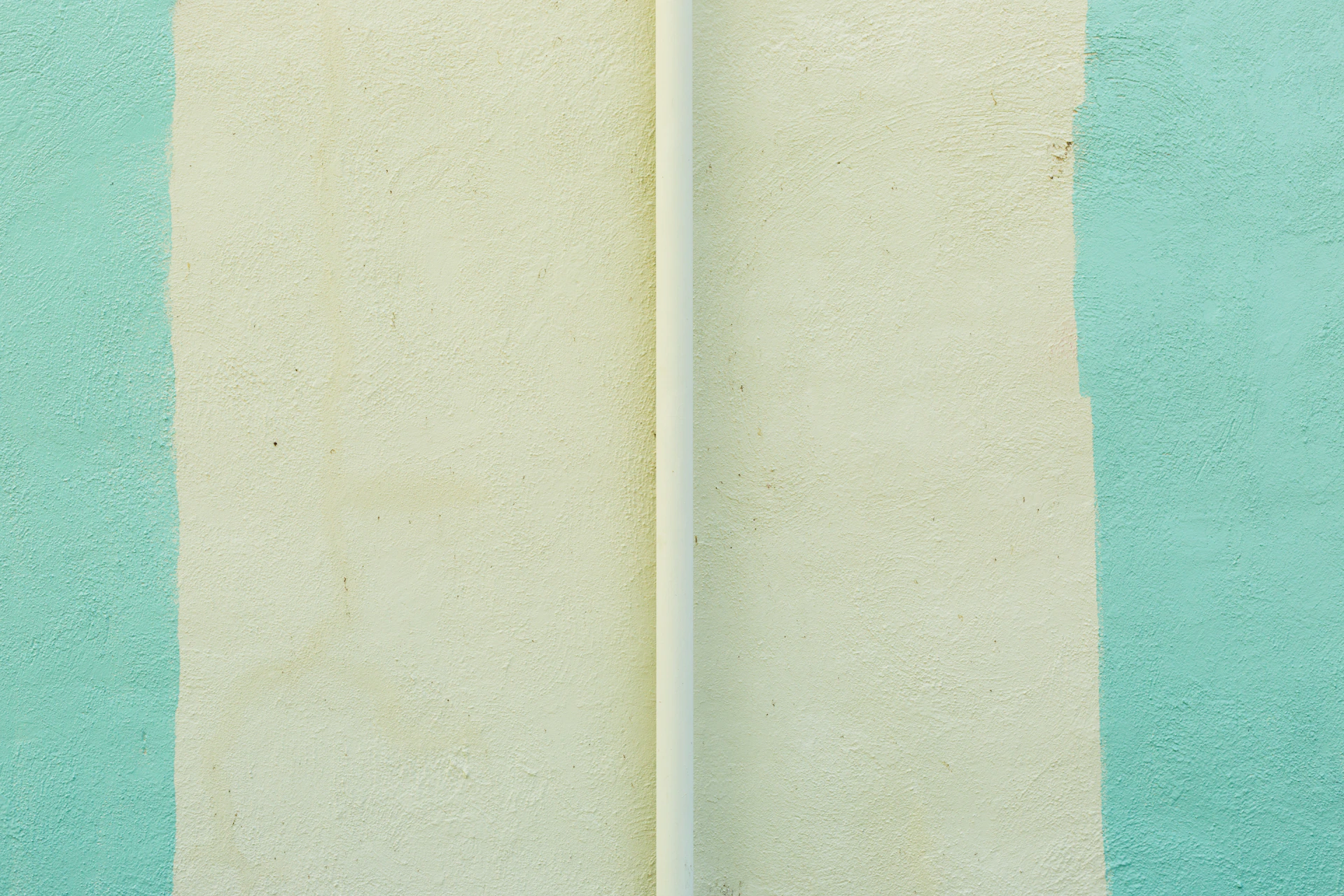 a white surfboard leaning against a blue and green wall