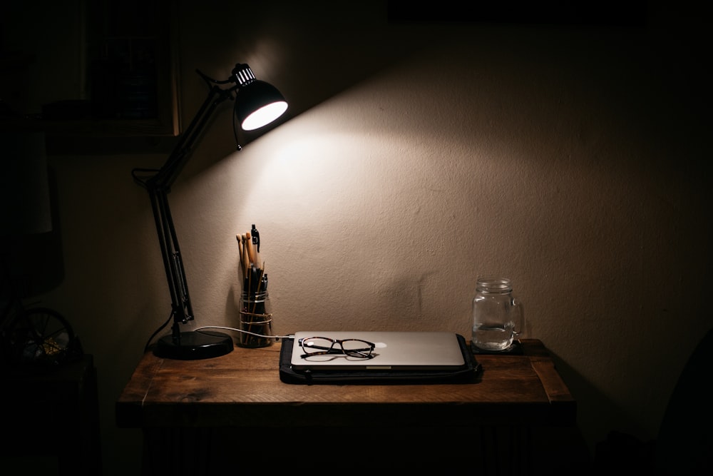 갈색 나무 테이블에 검은 책상 램프