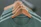 Front-facing men's olive green overshirt centered on a light-neutral background with soft studio lighting showing sharp details and natural fabric folds.