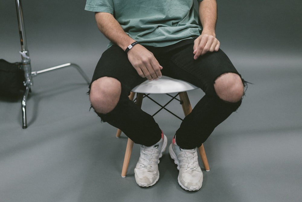 personne assise sur un tabouret en bois blanc