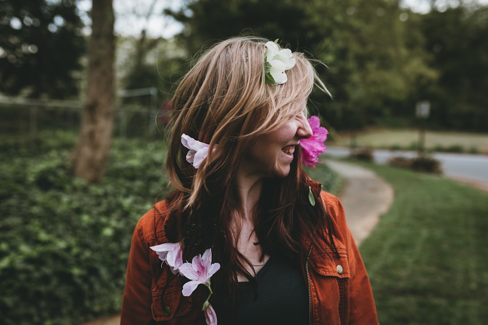 smiling woman standing near trees during daytime