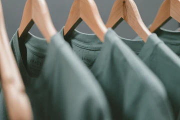 Sage tees on wooden hangers