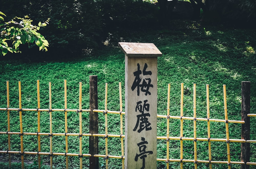 Texte kanji sur panneau mural en bois près de la clôture