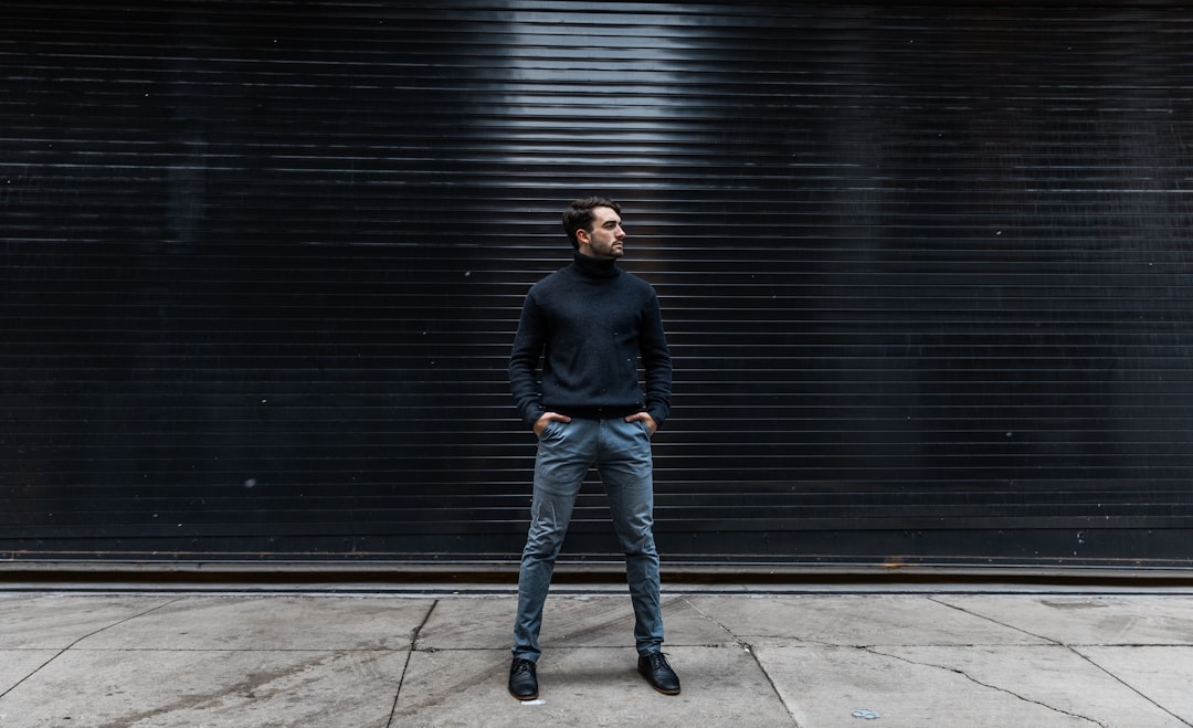 man standing near black shutter door