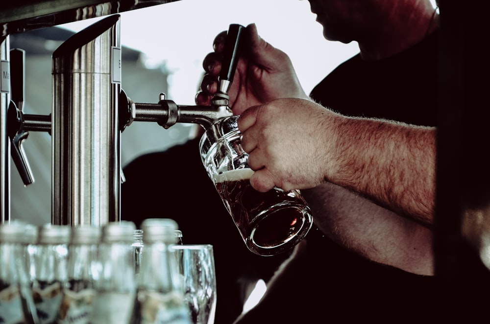 persona sosteniendo una jarra de cerveza