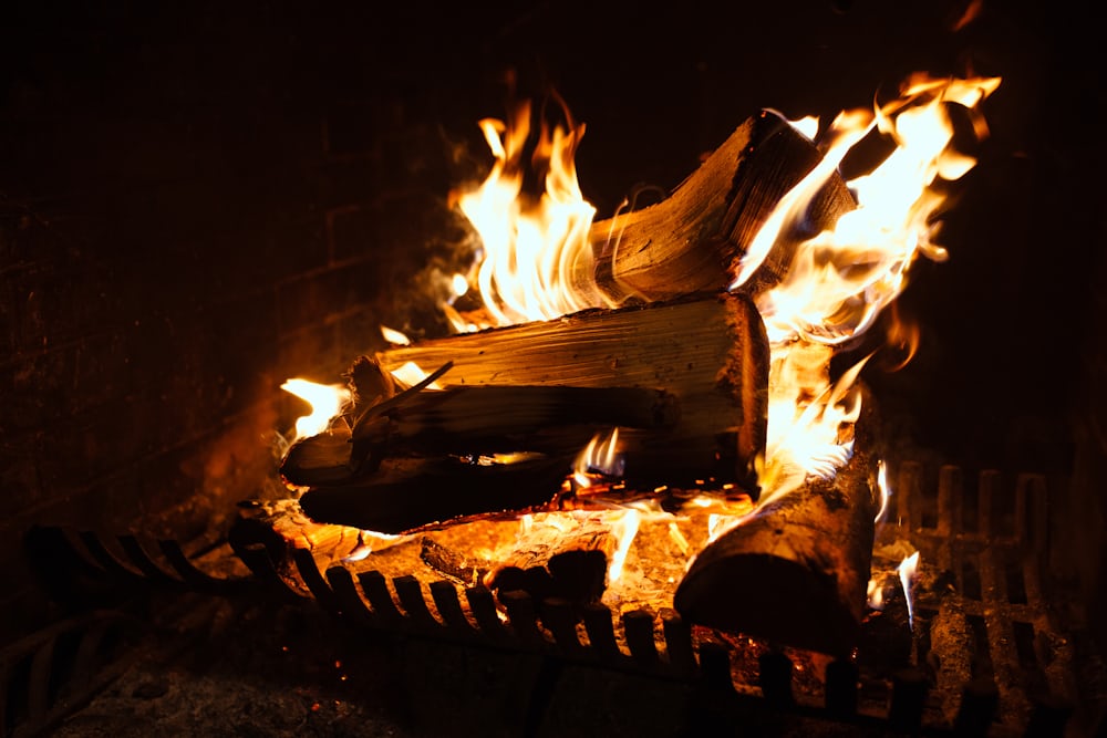 Log fire burning in a home fireplace grate after a professional sweep