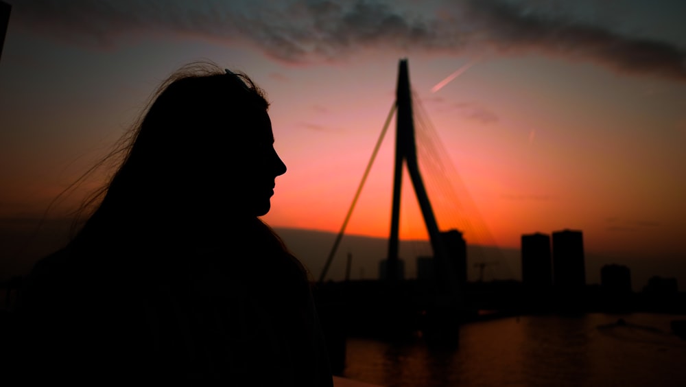 silhouette of person hear bridge