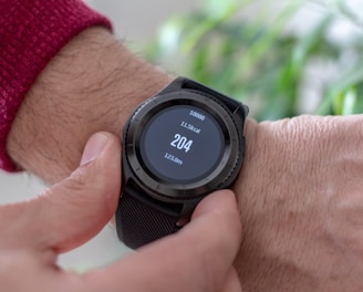 person wearing round black smartwatch