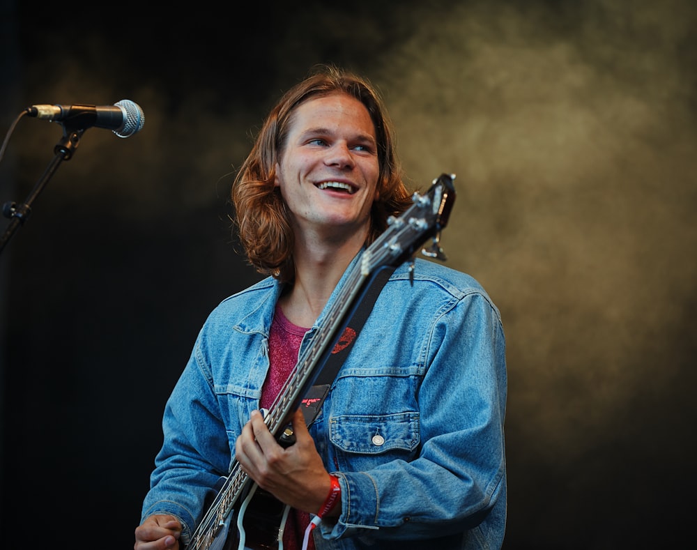 man playing guitar while looking sideway