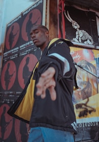 man wearing jacket near wall in room