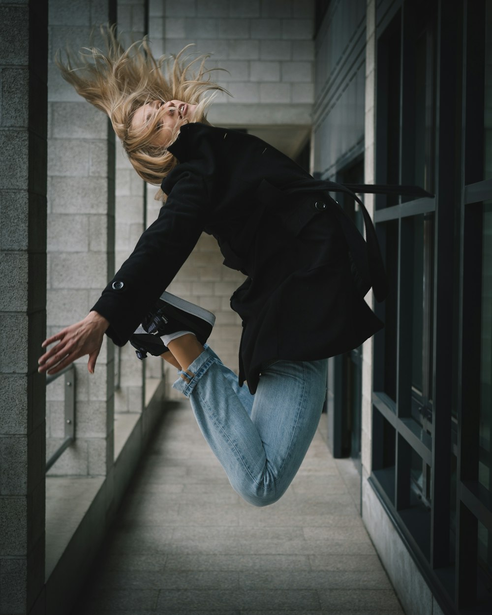 man wearing black coat jumping