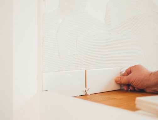 person holding white tile