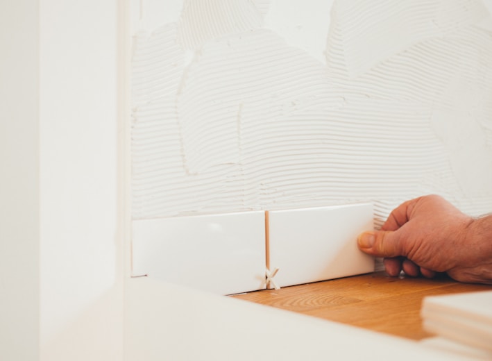 person holding white tile