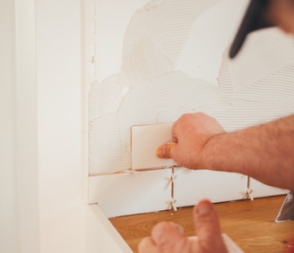 person pressing white wall