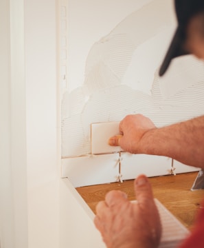 person pressing white wall