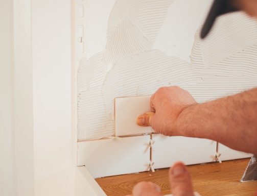 person pressing white wall