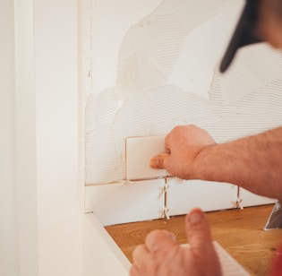 person pressing white wall