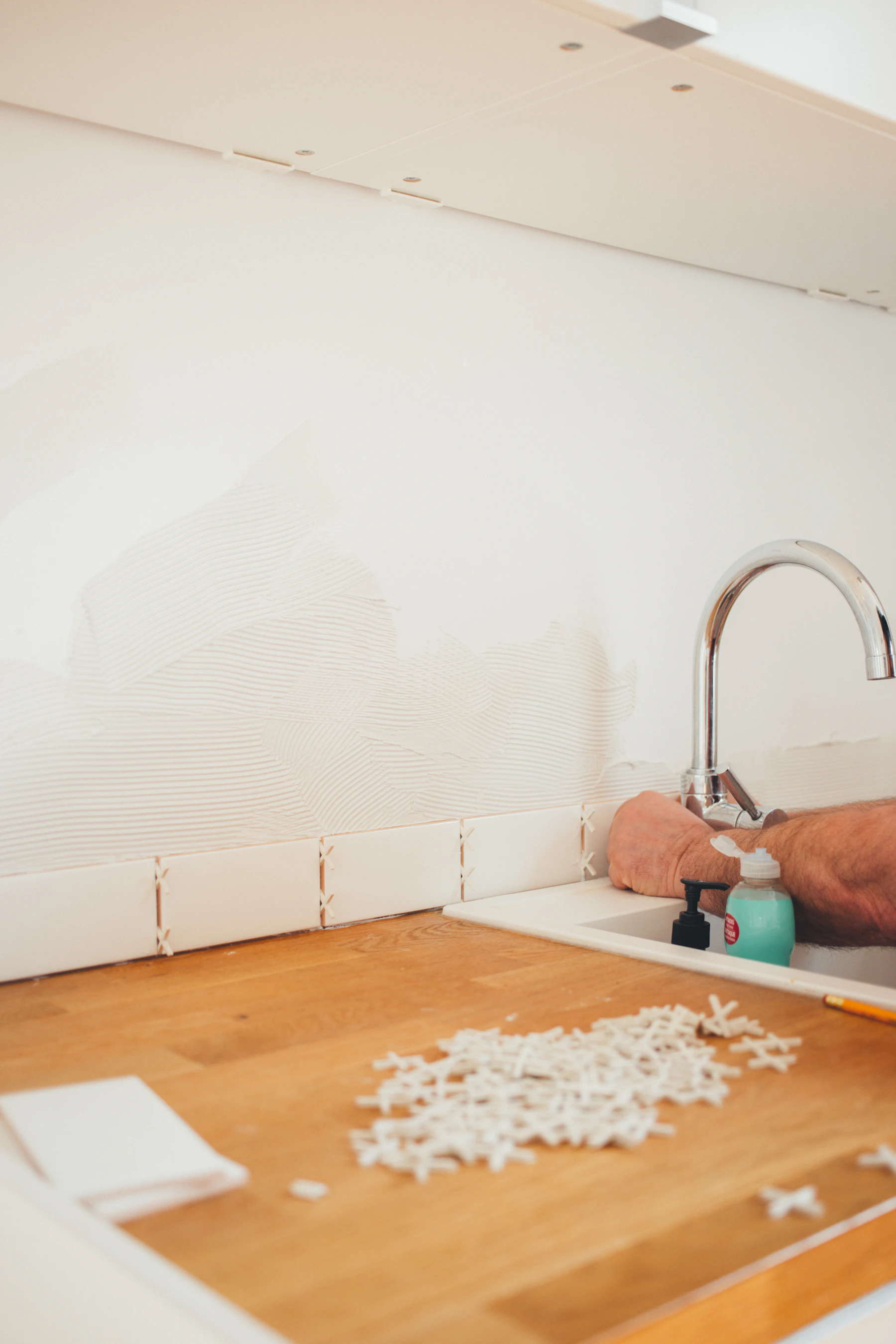 A technician checking hot water flow and temperature at a fixture fed by a tankless unit