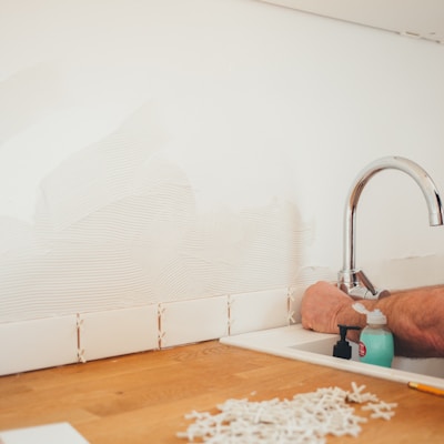 person holding gray curved faucet