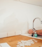 person holding gray curved faucet