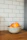 three orange fruit in white ceramic bowls on table