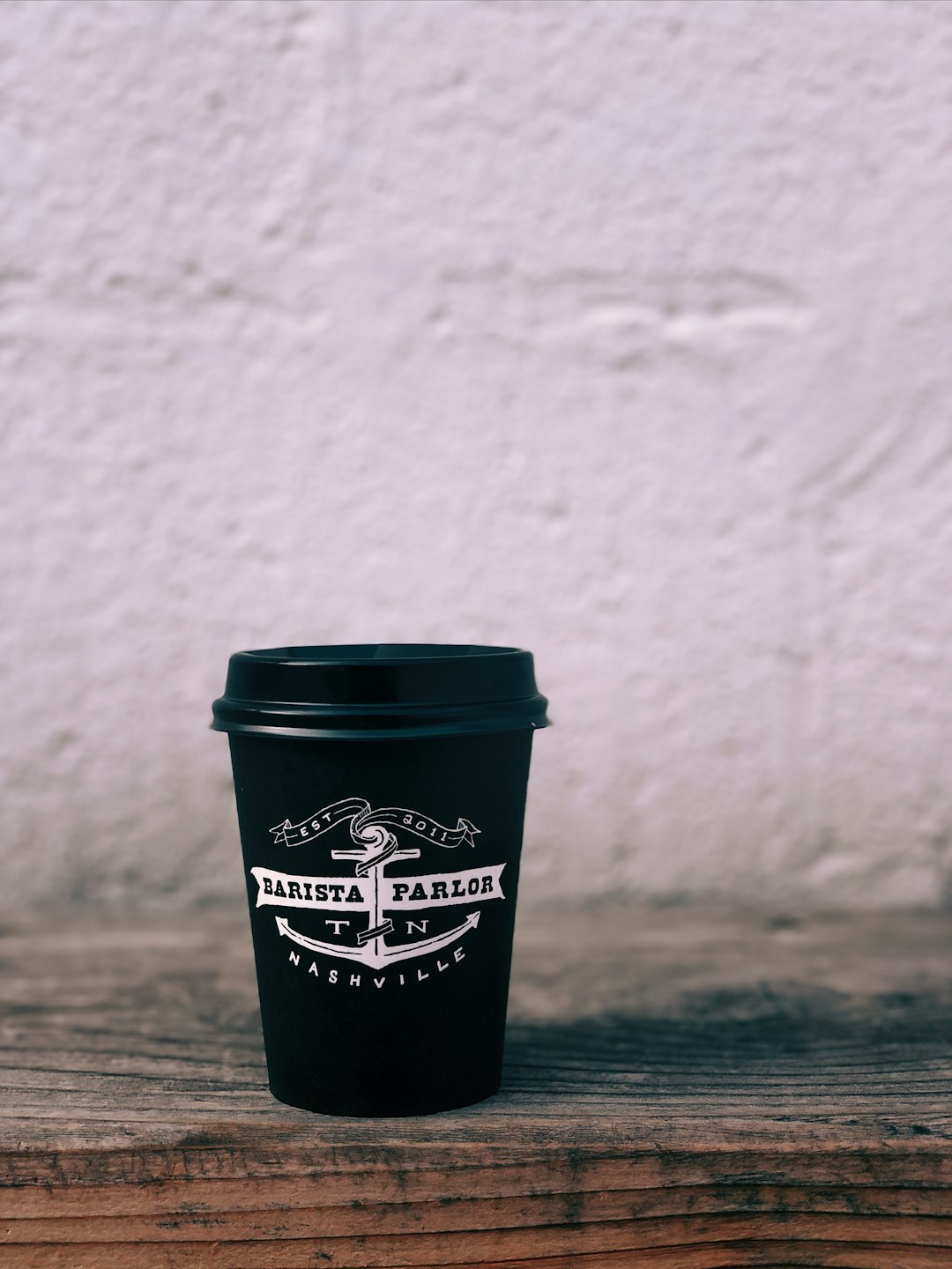 black and white Barista Parlor disposable cup on table