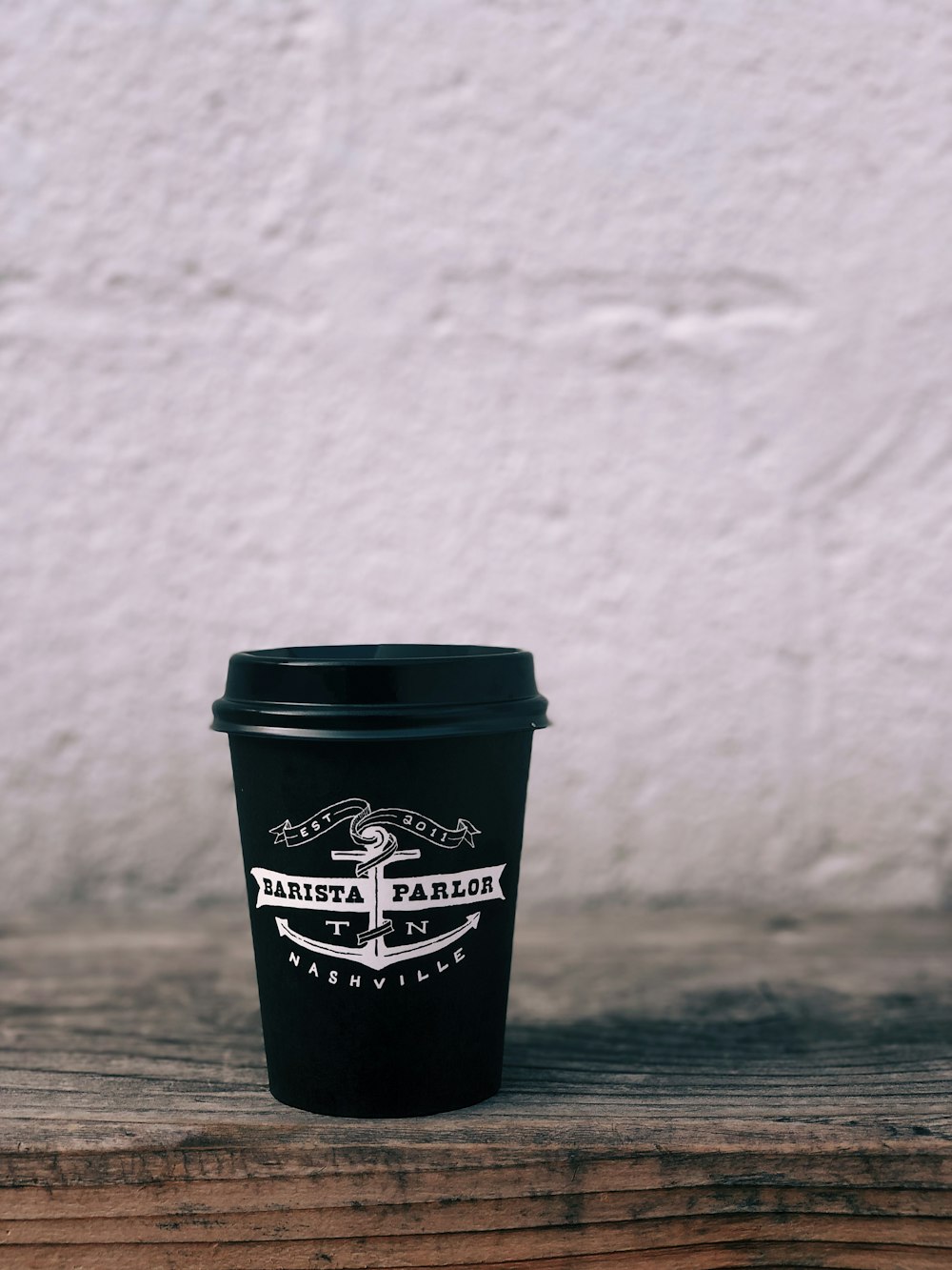 black and white Barista Parlor disposable cup on table