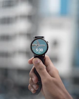 Smartwatch screen showing health stats with a blurred cityscape in the background during golden hour.