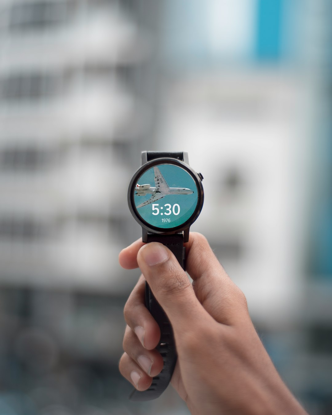 selective focus photography of person holding black smartwatch displaying 5:30