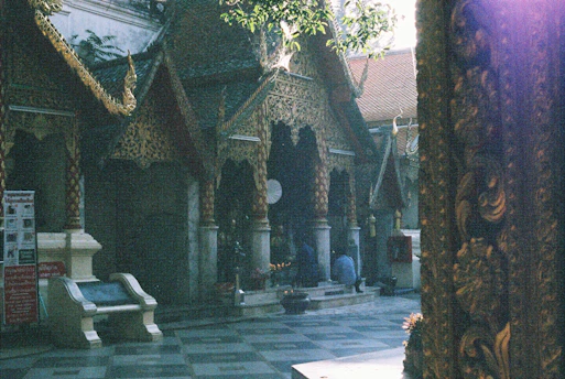 A serene temple courtyard bathed in golden afternoon light, with a traveler admiring the intricate carvings.