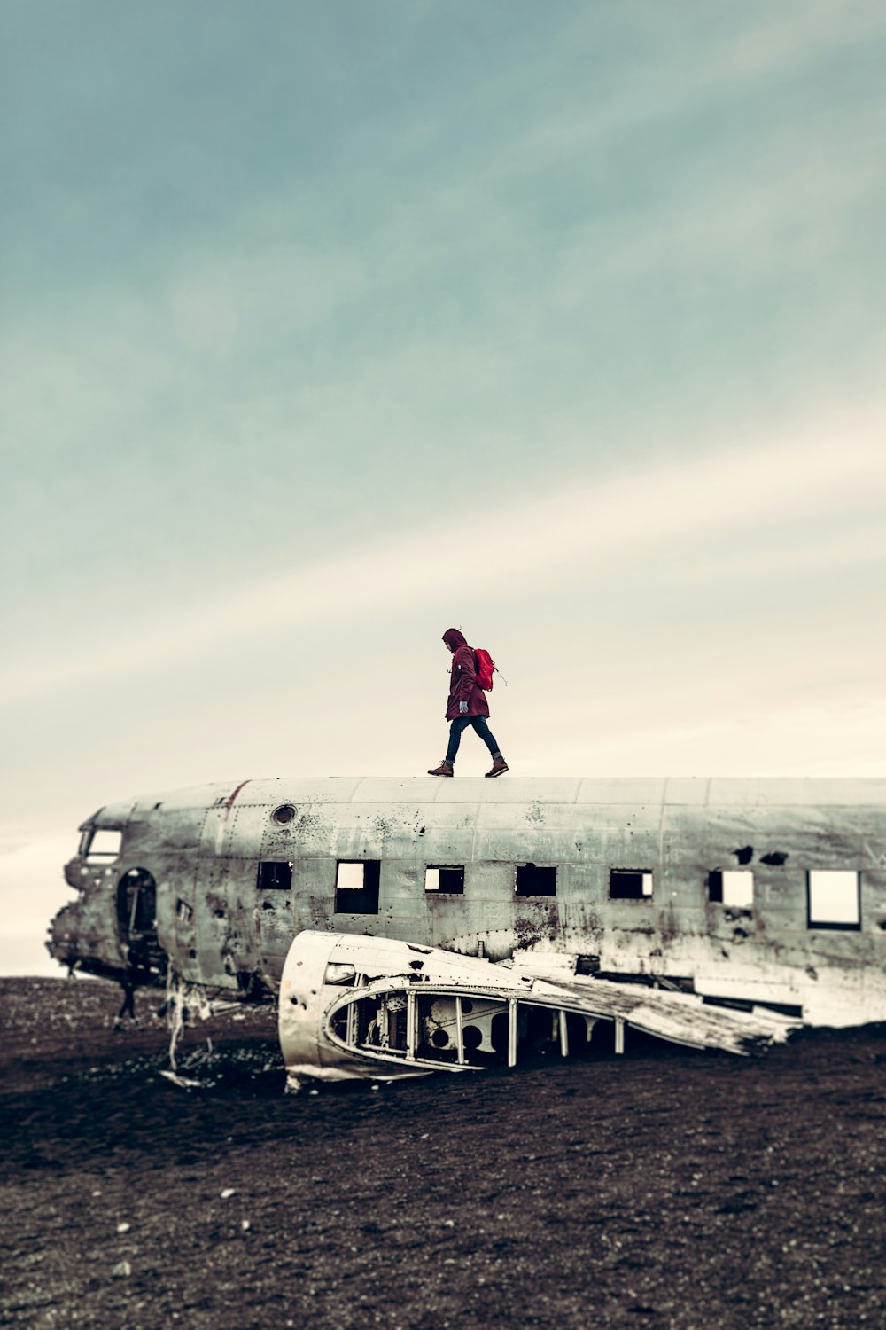 난파된 비행기 위를 걷고 있는 사람의 사진
