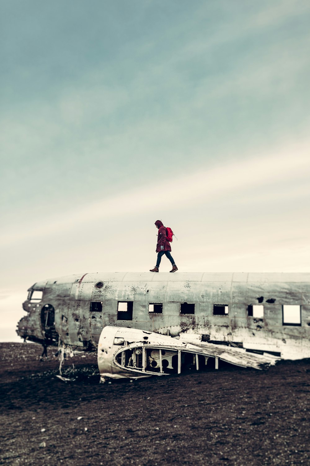 墜落した飛行機の上を歩いている人の写真