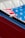 Close-up of a red car interior showing part of the door and an American flag in the background.