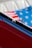 Close-up of a red car interior showing part of the door and an American flag in the background.