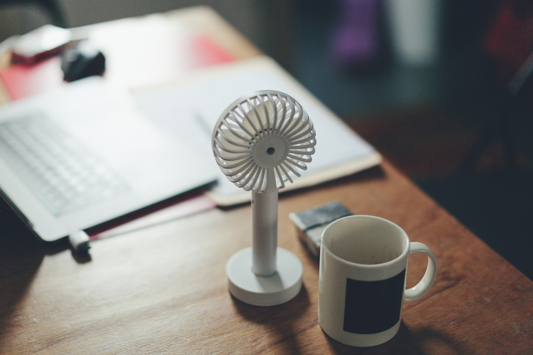  photo of white mug on table fan